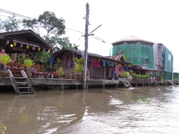 Old wooden houses and new hotel at Amphawa